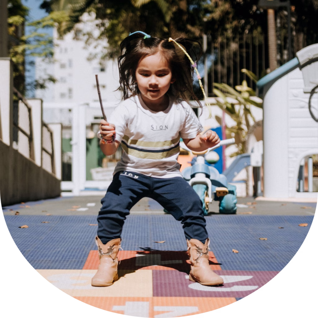 Criança da Educação Infantil do Colégio Sion Higienópolis brincando em atividade de movimento no espaço escolar.