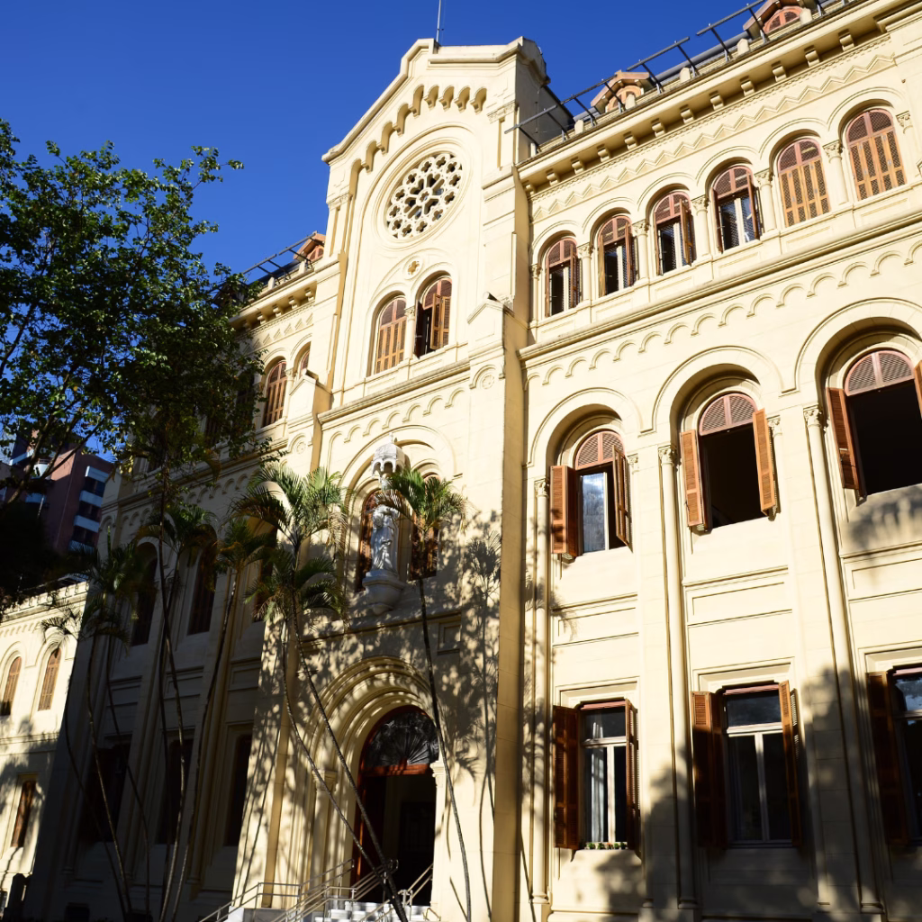 Entrada do prédio histórico do Colégio Sion Higienópolis, em São Paulo, com fachada, escadaria e elementos arquitetônicos preservados.