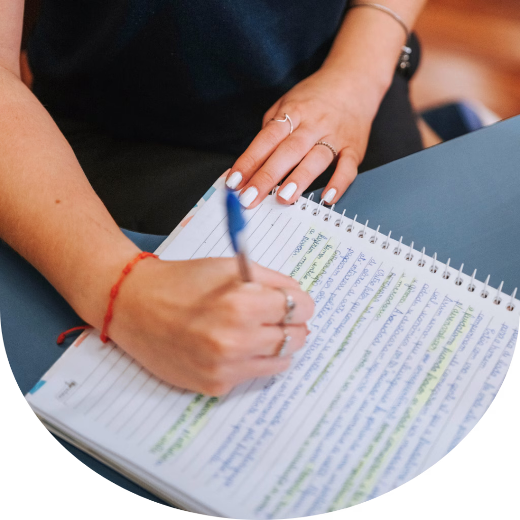 Estudante do Colégio Sion Higienópolis realizando atividade de estudo e escrita em caderno.